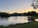 Scenic lake view with home in the background with sunset at 23310 Cascade Pl, Land O Lakes, FL 34639