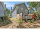 View of the backyard showing the deck and the side of the house, with a small pathway and some greenery at 290 Winchester Way, Palm Harbor, FL 34684