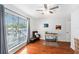 Hardwood floor bedroom featuring a ceiling fan and large window at 290 Winchester Way, Palm Harbor, FL 34684