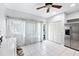 Spacious kitchenette with white tile floors, stainless steel refrigerator, and a bright view at 290 Winchester Way, Palm Harbor, FL 34684