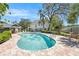Relaxing community pool area features a cabana, comfortable lounge chairs, and lush landscaping under a beautiful blue sky at 290 Winchester Way, Palm Harbor, FL 34684