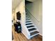 A modern stairway with wood treads, carpet runners, and a sleek white railing at 3037 Jacob Crossing Ln, Holiday, FL 34691