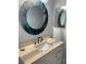 Elegant bathroom vanity featuring a round mirror, modern faucet, and ample counter space at 3054 Pelican Pl, Clearwater, FL 33762