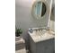 Cozy bathroom featuring a round mirror, marble countertop, and a stylish faucet set at 3054 Pelican Pl, Clearwater, FL 33762