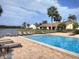 Resort-style community pool with lounge chairs, beautiful landscaping, and lake views at 3054 Pelican Pl, Clearwater, FL 33762