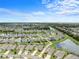 Overhead neighborhood view with a pond and neatly manicured lawns under a clear blue sky at 30639 Summer Sun Loop, Wesley Chapel, FL 33545