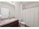 Well-lit bathroom featuring a shower with curtain, toilet, sink, and wood-look flooring at 30639 Summer Sun Loop, Wesley Chapel, FL 33545