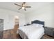 Well-lit bedroom offers a ceiling fan, wood-look floors, and an accessible bathroom at 30639 Summer Sun Loop, Wesley Chapel, FL 33545