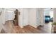 Bright, open foyer with wood-look floors, storage bench and access to bedroom and main living area at 30639 Summer Sun Loop, Wesley Chapel, FL 33545