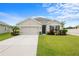 Charming single-story home showcasing a well-maintained lawn, two-car garage, and lovely front yard at 30639 Summer Sun Loop, Wesley Chapel, FL 33545