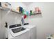 Functional laundry room is equipped with shelving, a washer, and a dryer at 30639 Summer Sun Loop, Wesley Chapel, FL 33545