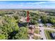 An aerial view of the property, nestled among trees with a pond nearby in a quiet residential neighborhood at 3142 Crenshaw Ct, New Port Richey, FL 34655