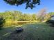 Serene backyard with water views, stone pathway, and a cozy fire pit area at 3142 Crenshaw Ct, New Port Richey, FL 34655