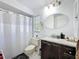 Bathroom with vanity, tan toilet, white shower curtain, and a white shuttered window at 3142 Crenshaw Ct, New Port Richey, FL 34655