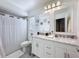 Bright bathroom featuring a double vanity with marble countertop and a shower with white curtain at 3142 Crenshaw Ct, New Port Richey, FL 34655