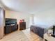 Bedroom with TV and black dresser featuring wood-look vinyl floors and white walls at 3142 Crenshaw Ct, New Port Richey, FL 34655