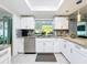 Updated kitchen showcasing white cabinets, granite countertops, and stainless steel appliances at 3142 Crenshaw Ct, New Port Richey, FL 34655