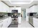 Functional kitchen with stainless steel appliances, granite countertops, and white cabinetry at 3142 Crenshaw Ct, New Port Richey, FL 34655