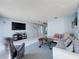 Bright living room featuring a comfortable gray sectional sofa, tile flooring, and coastal-themed decor at 3142 Crenshaw Ct, New Port Richey, FL 34655