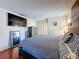 Comfortable main bedroom featuring hardwood floors, neutral tones, and a mounted television at 3142 Crenshaw Ct, New Port Richey, FL 34655
