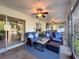 Relaxing screened patio featuring comfortable wicker furniture, ceiling fans, and views of the outdoor landscape at 3142 Crenshaw Ct, New Port Richey, FL 34655