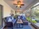 Relaxing screened patio featuring comfortable wicker furniture, ceiling fans, and views of the landscaped yard at 3142 Crenshaw Ct, New Port Richey, FL 34655