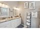Bathroom featuring double sinks with granite countertops and decorative artwork at 3215 Hibiscus Dr, Hernando Beach, FL 34607