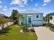 Charming home with blue siding, manicured lawn, palm trees, and an attached garage at 3215 Hibiscus Dr, Hernando Beach, FL 34607