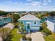 Charming blue waterfront home with lush landscaping, a well-manicured lawn, and beautiful water views at 3215 Hibiscus Dr, Hernando Beach, FL 34607