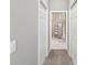 Hallway leading to bathroom with white tile flooring, linen closet, and decorative accents at 3215 Hibiscus Dr, Hernando Beach, FL 34607