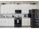 Beautiful kitchen includes white cabinets, black appliances, granite counters, and decorative accents at 3215 Hibiscus Dr, Hernando Beach, FL 34607