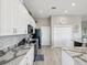 Kitchen with white cabinets, black appliances, granite countertops, and hardwood floors at 3215 Hibiscus Dr, Hernando Beach, FL 34607