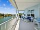 Covered patio with comfortable seating area and a grill, overlooking a serene waterfront view at 3215 Hibiscus Dr, Hernando Beach, FL 34607