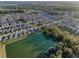 Aerial view of a residential neighborhood bordering a pond with mature trees, offering a serene living environment at 36419 Flats St, Zephyrhills, FL 33541