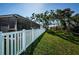 Beautiful backyard with a white fence and lush green lawn and mature shade trees at 36419 Flats St, Zephyrhills, FL 33541