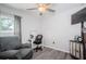 Bright bedroom with a gray accent chair, desk, and gray wood-look flooring at 36419 Flats St, Zephyrhills, FL 33541
