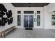Welcoming entrance with black double doors, contemporary lighting, wood-look siding, and decorative wall art at 36419 Flats St, Zephyrhills, FL 33541