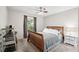 Well-lit bedroom with a wooden bed frame, neutral-colored walls, and large window with gray curtains at 3741 Appleton Ct, Palm Harbor, FL 34684