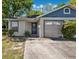 Charming single-story home featuring a front yard and attached garage on a sunny day at 3741 Appleton Ct, Palm Harbor, FL 34684