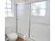 Bathroom featuring a toilet and shower stall with glass doors and a bright window at 4009 Triggerfish Dr, Hernando Beach, FL 34607