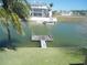 Overhead view of a private wooden dock on tranquil waters with a house in the background at 4009 Triggerfish Dr, Hernando Beach, FL 34607