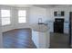 Bright kitchen with a large island, granite countertops, stainless steel appliances, and wood flooring at 4009 Triggerfish Dr, Hernando Beach, FL 34607