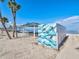 Beach access point shows covered picnic tables near water and decorative art at 4237 Marine Pkwy, New Port Richey, FL 34652