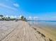 Scenic beachside with pristine sand and tranquil water, complemented by a nearby seating area at 4237 Marine Pkwy, New Port Richey, FL 34652