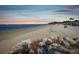 Expansive beach scene with natural rock formations, a calm sea, and a distant sunset, perfect for relaxation at 4237 Marine Pkwy, New Port Richey, FL 34652