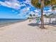 Scenic beach view with turquoise waters, white sand, and charming seating areas under the shade of palm trees at 4237 Marine Pkwy, New Port Richey, FL 34652