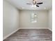 A bright bedroom with wood-look floors, neutral walls, and a ceiling fan at 4237 Marine Pkwy, New Port Richey, FL 34652