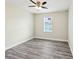 Cozy bedroom with wood-look floors, a ceiling fan, and a sunlit window at 4237 Marine Pkwy, New Port Richey, FL 34652