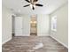 Spacious bedroom featuring wood-look floors, a ceiling fan, and an en suite bathroom at 4237 Marine Pkwy, New Port Richey, FL 34652
