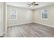 Bright and airy bedroom featuring two windows, wood-look floors, and a ceiling fan at 4237 Marine Pkwy, New Port Richey, FL 34652